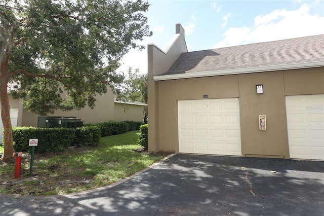 view of property exterior featuring central AC unit and a garage