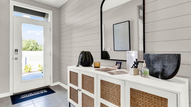 entryway featuring tile patterned floors and wood walls