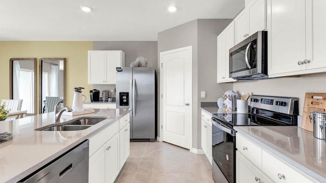 kitchen featuring white cabinets, stainless steel appliances, sink, and light tile patterned floors