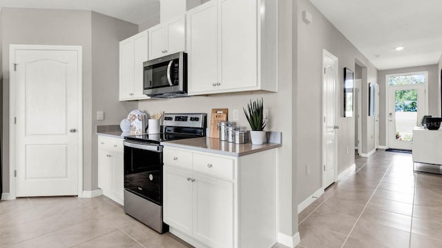 kitchen featuring light tile patterned flooring, white cabinetry, and stainless steel appliances