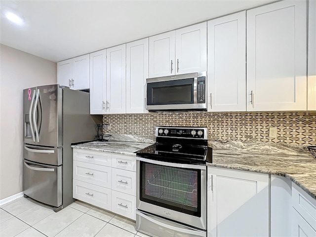 kitchen featuring white cabinetry, stainless steel appliances, backsplash, and light tile patterned flooring