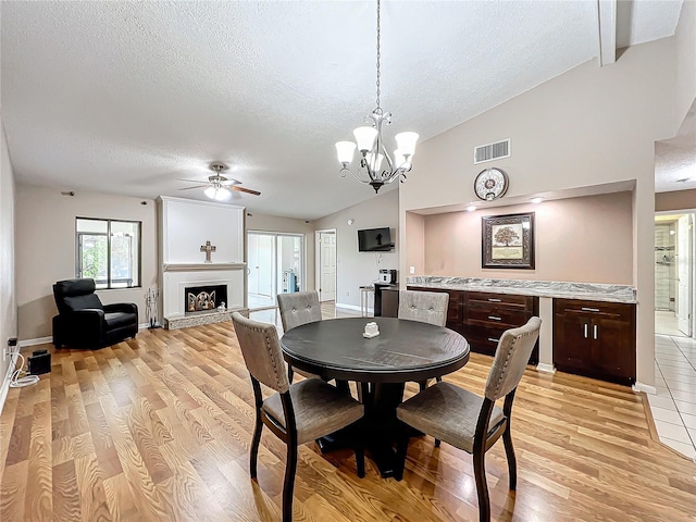 dining room with light hardwood / wood-style floors, a textured ceiling, and beam ceiling