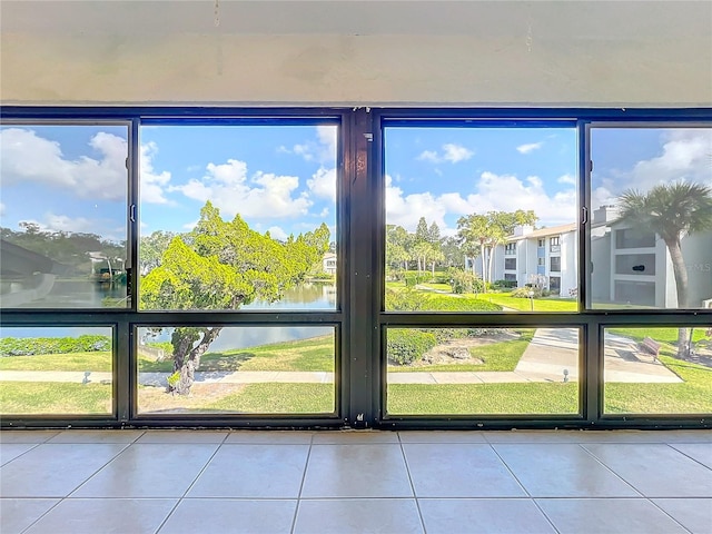 entryway featuring tile patterned floors, a water view, and plenty of natural light