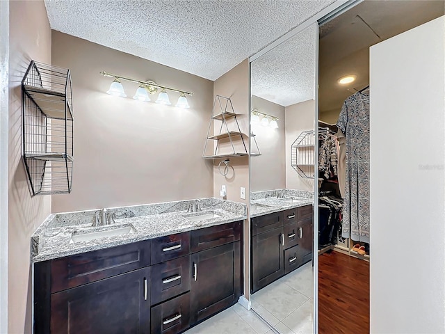 bathroom featuring vanity, hardwood / wood-style floors, and a textured ceiling