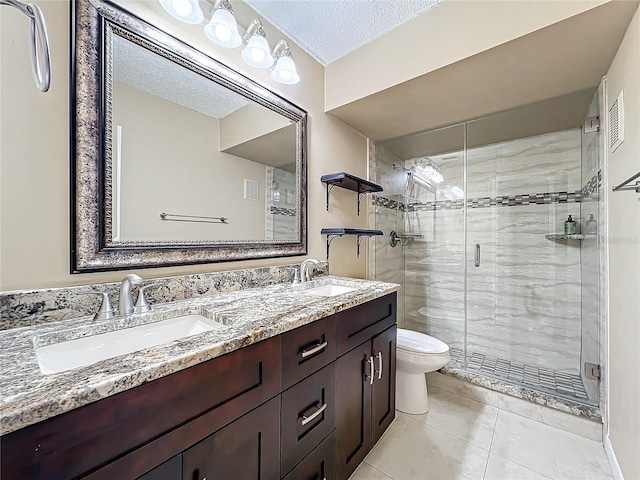 bathroom featuring a textured ceiling, toilet, walk in shower, vanity, and tile patterned flooring