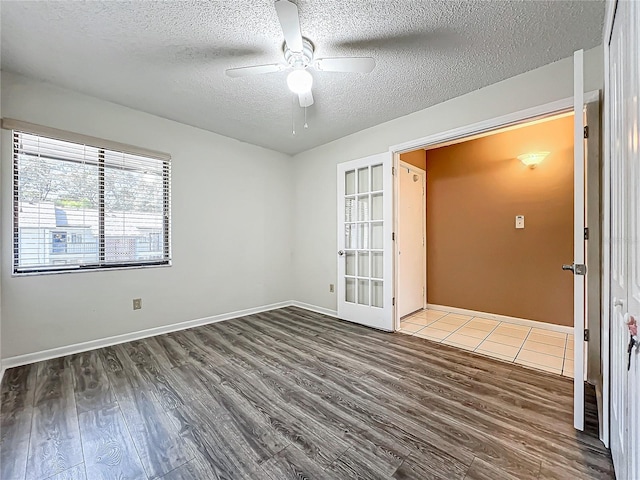 spare room with french doors, ceiling fan, a textured ceiling, and dark hardwood / wood-style flooring