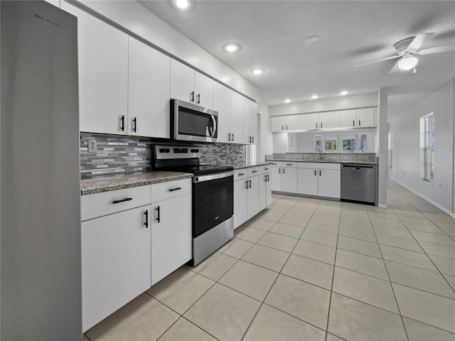 kitchen featuring stainless steel appliances, tasteful backsplash, light tile patterned floors, white cabinetry, and ceiling fan