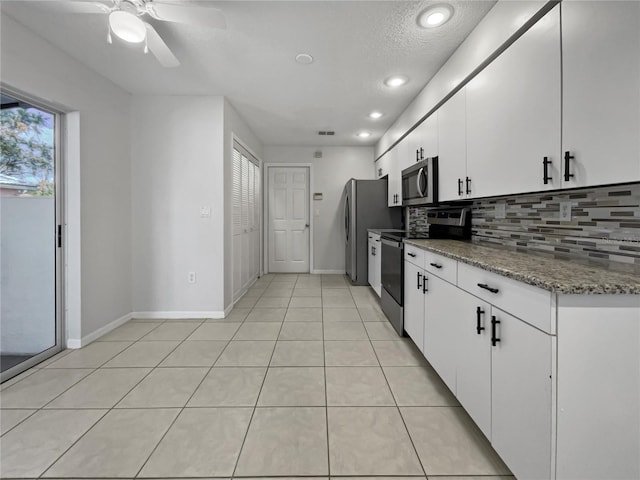 kitchen featuring white cabinets, backsplash, appliances with stainless steel finishes, a textured ceiling, and stone counters