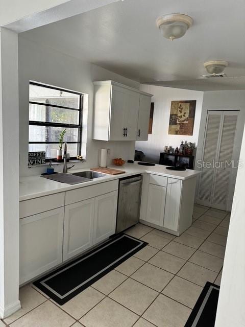 kitchen featuring white cabinets, dishwasher, sink, and light tile patterned floors