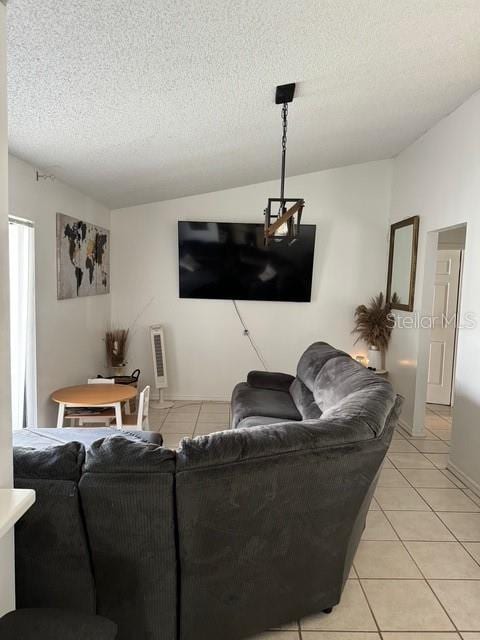 living room with vaulted ceiling, a textured ceiling, and light tile patterned floors