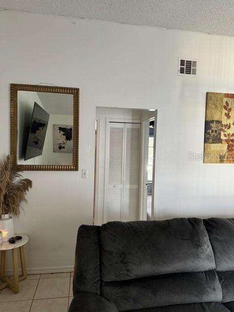 tiled living room featuring a textured ceiling