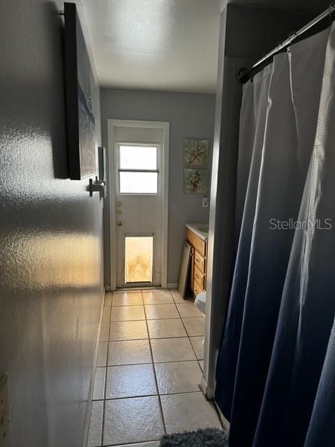 bathroom featuring vanity, tile patterned floors, and curtained shower