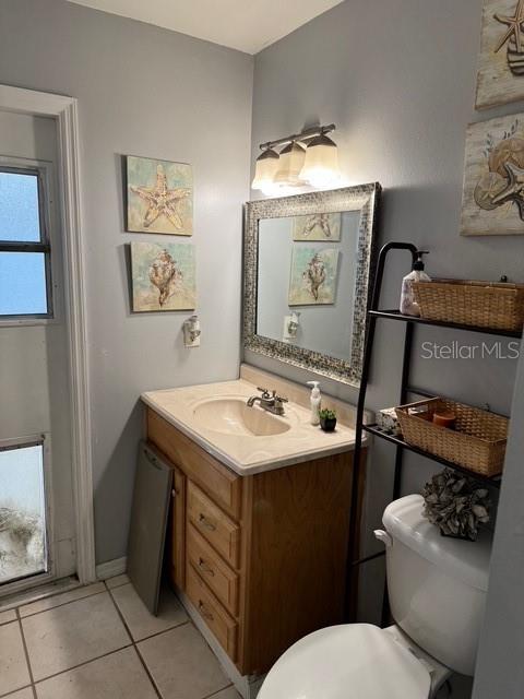 bathroom featuring vanity, toilet, and tile patterned flooring