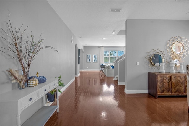 corridor featuring dark wood-type flooring and a textured ceiling