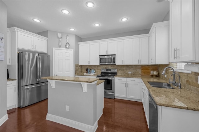 kitchen featuring white cabinets, dark hardwood / wood-style floors, stainless steel appliances, sink, and a center island