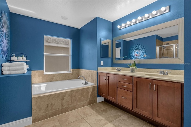 bathroom with vanity, a textured ceiling, separate shower and tub, and tile patterned flooring