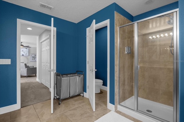 bathroom featuring toilet, an enclosed shower, tile patterned flooring, and ceiling fan