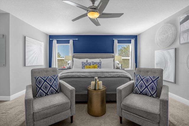 carpeted bedroom with a ceiling fan, a textured ceiling, and baseboards