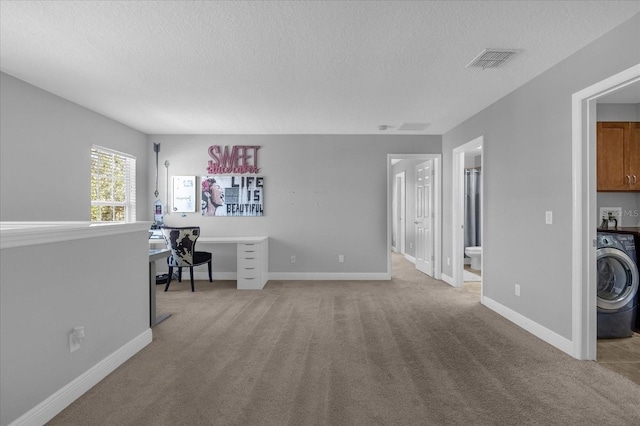 office area with light carpet, washer / clothes dryer, visible vents, and baseboards