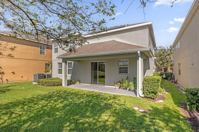 rear view of property featuring a patio, central AC, a shingled roof, a yard, and stucco siding