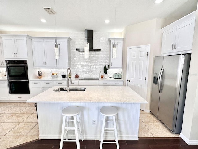 kitchen featuring a breakfast bar, white cabinetry, black appliances, pendant lighting, and sink