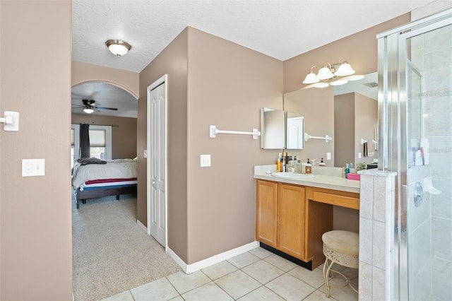 bathroom with a shower with door, tile patterned flooring, vanity, a textured ceiling, and ceiling fan