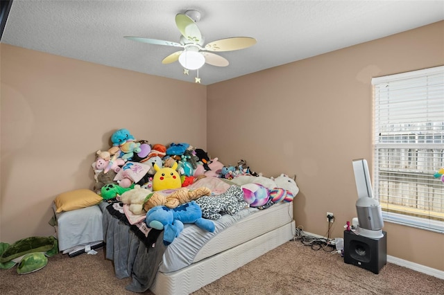 carpeted bedroom featuring a textured ceiling and ceiling fan