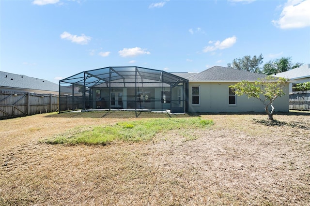 rear view of house featuring glass enclosure