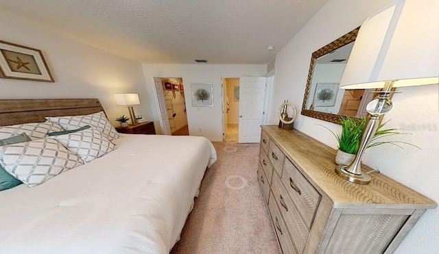 bedroom with light carpet and a textured ceiling