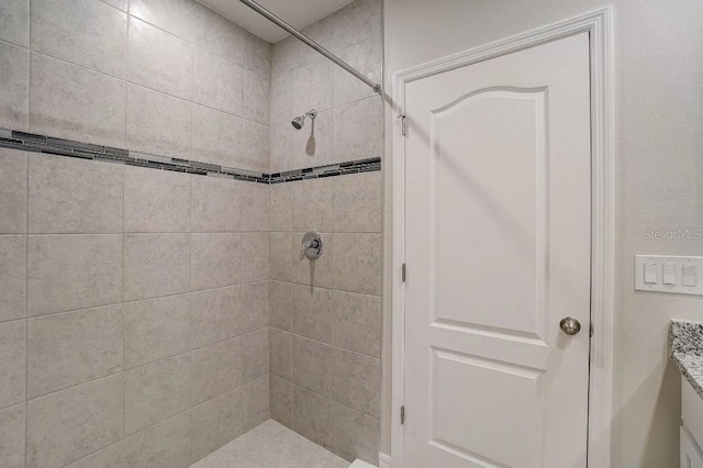 bathroom featuring vanity and tiled shower