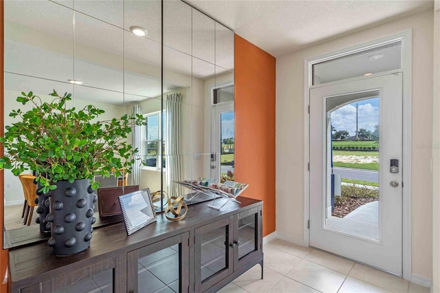 foyer with a textured ceiling and light tile patterned floors