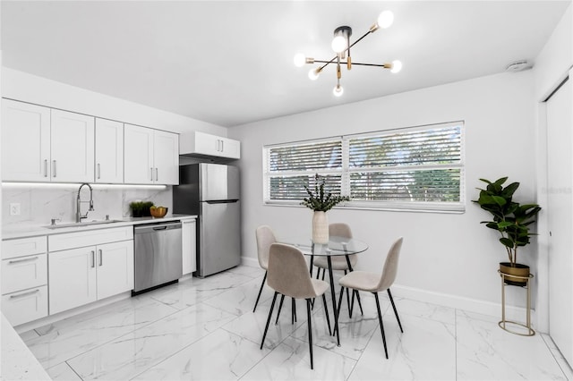 kitchen featuring appliances with stainless steel finishes, white cabinetry, sink, and plenty of natural light