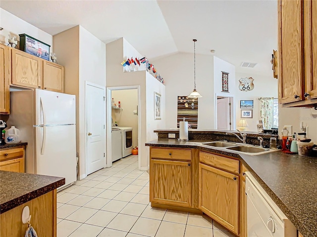 kitchen with lofted ceiling, independent washer and dryer, pendant lighting, sink, and white appliances