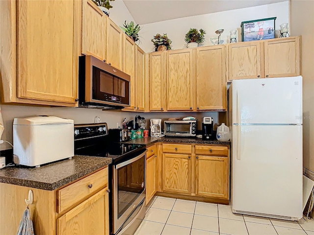 kitchen featuring stainless steel appliances, light tile patterned floors, and light brown cabinets