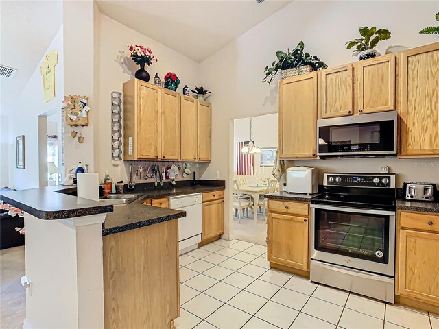 kitchen featuring kitchen peninsula, stainless steel appliances, sink, light tile patterned floors, and high vaulted ceiling