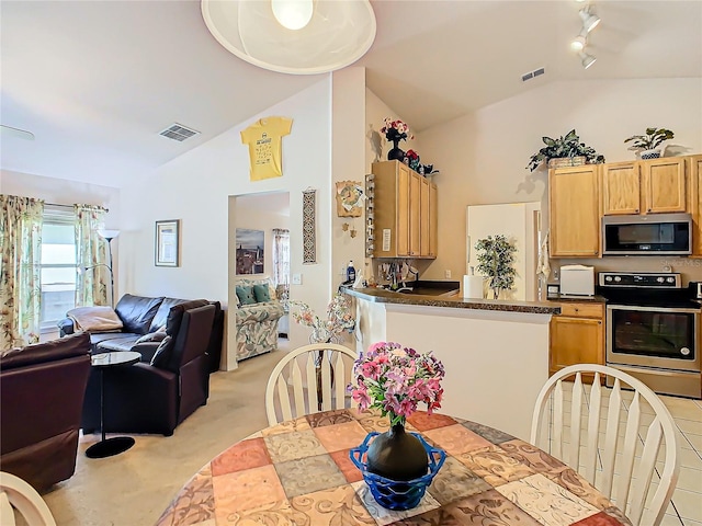 dining area with lofted ceiling, light carpet, and rail lighting