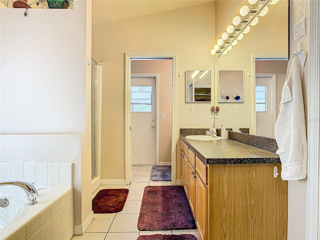 bathroom with vanity, independent shower and bath, vaulted ceiling, and plenty of natural light