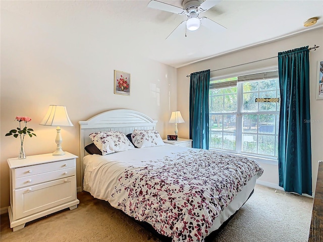 bedroom with ceiling fan and dark colored carpet