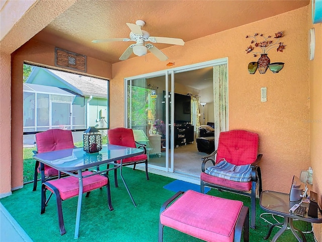 view of patio / terrace with ceiling fan and glass enclosure