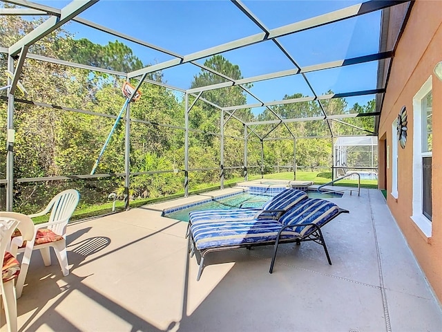 view of patio / terrace with a pool with hot tub and a lanai