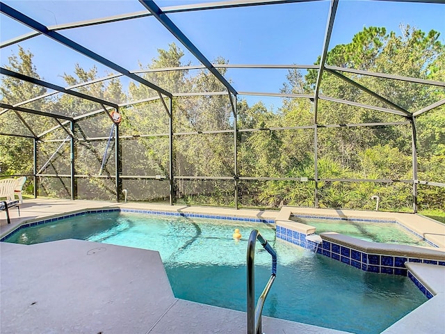 view of pool featuring an in ground hot tub, a patio area, and glass enclosure