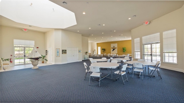 carpeted dining area with a wealth of natural light and french doors