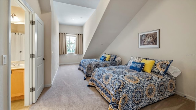 carpeted bedroom featuring connected bathroom and sink