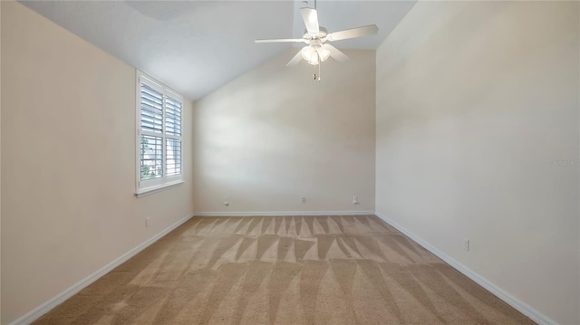 carpeted empty room featuring ceiling fan and lofted ceiling