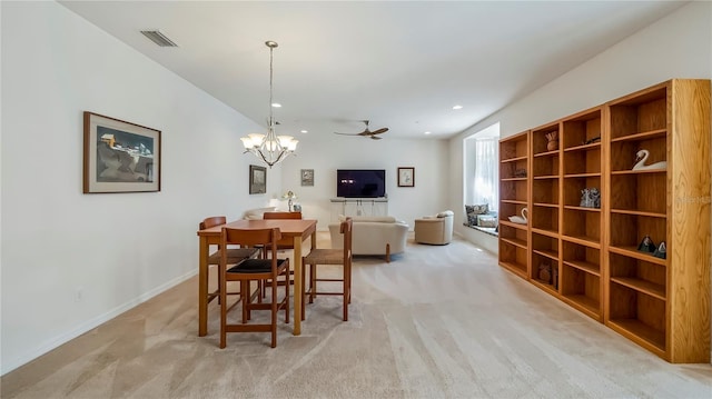 carpeted dining area with ceiling fan with notable chandelier