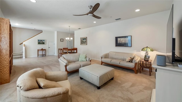 living room featuring light carpet and ceiling fan with notable chandelier