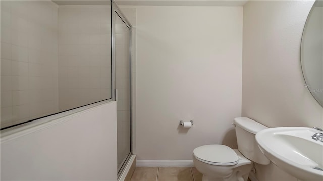 bathroom with toilet, tile patterned floors, walk in shower, and sink