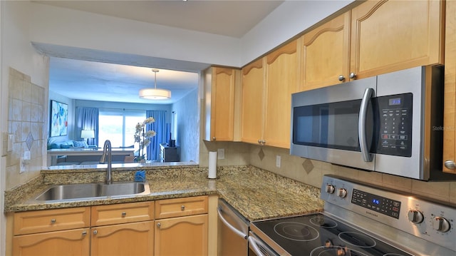 145 N Halifax Ave Unit 711, Daytona Beach, FL 32118 - kitchen with tasteful backsplash, appliances with stainless steel finishes, sink, and light brown cabinets