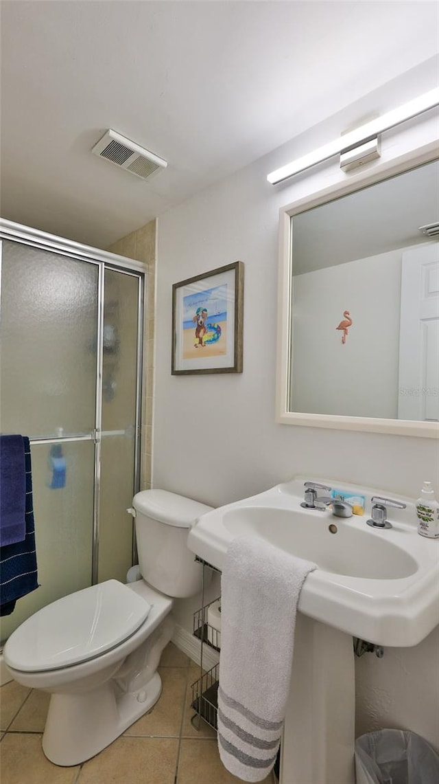 145 N Halifax Ave Unit 711, Daytona Beach, FL 32118 - bathroom featuring toilet, a shower with shower door, and tile patterned flooring
