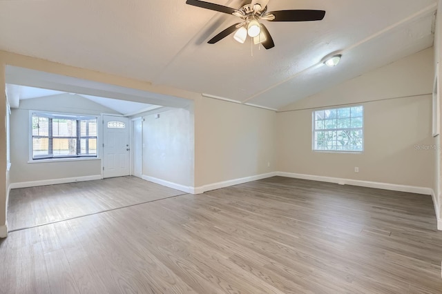 empty room featuring lofted ceiling, hardwood / wood-style flooring, and ceiling fan